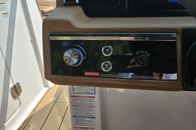 Slide: The Image of Control panel of 2025 Chaparral 267 SSX boat with horn and blower buttons. - 17