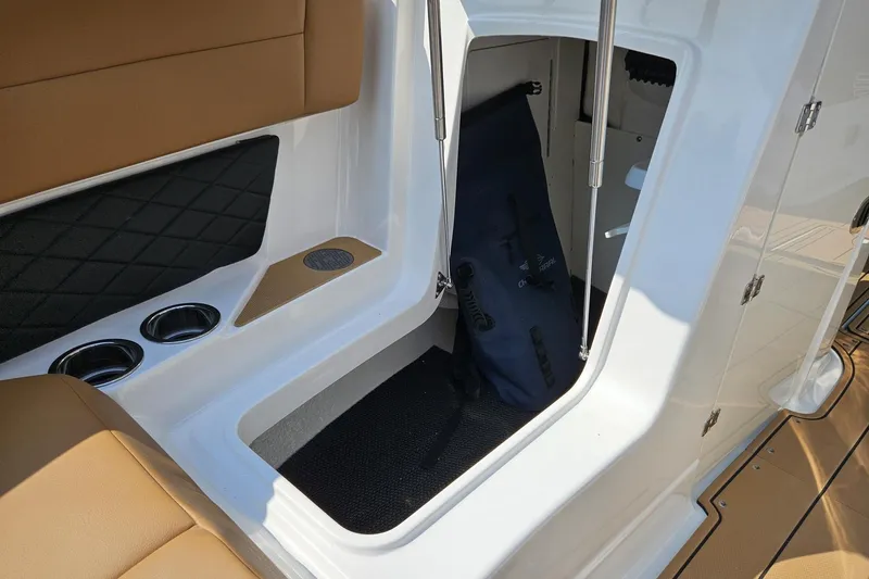 Slide: The Image of 2025 Chaparral 267 SSX boat interior storage compartment with cup holders and seating. - 19