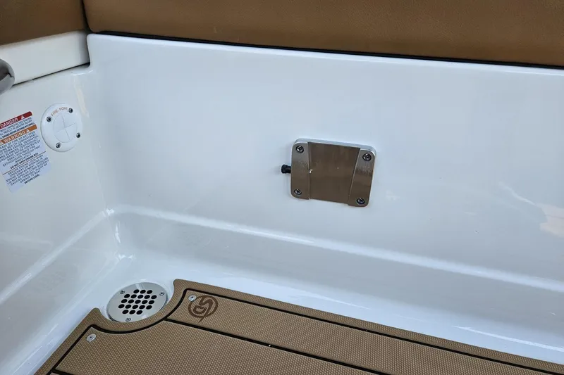 Slide: The Image of 2025 Chaparral 267 SSX boat interior detail with white panel and brown flooring. - 24