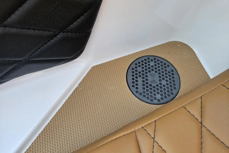 Slide: The Image of Interior detail of 2025 Chaparral 267 SSX with black and tan upholstery and speaker. - 25
