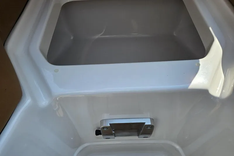Slide: The Image of Storage compartment in 2025 Chaparral 267 SSX boat, featuring sleek white interior design. - 29