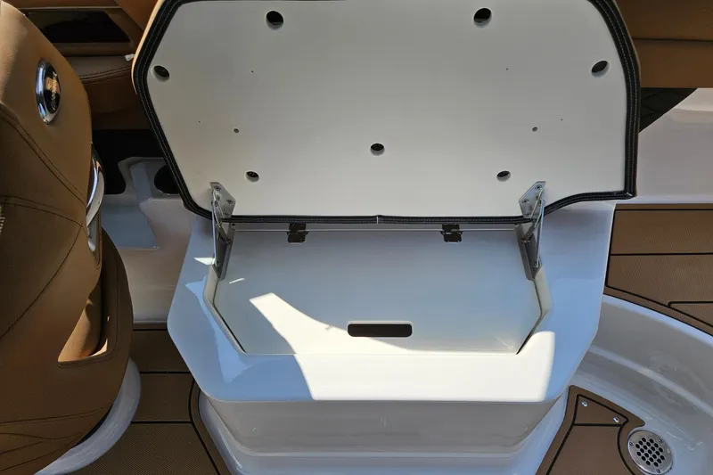 Slide: The Image of Open storage compartment on 2025 Chaparral 267 SSX boat, featuring sleek design and brown seating. - 34