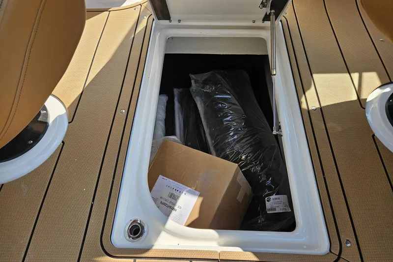 Slide: The Image of Storage compartment on 2025 Chaparral 267 SSX boat with items inside. - 38