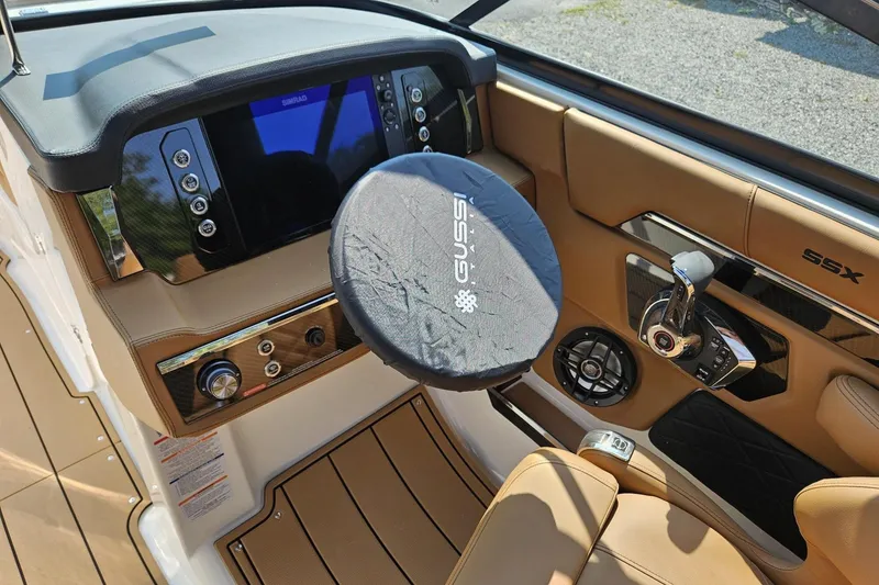 Slide: The Image of 2025 Chaparral 267 SSX boat dashboard with steering wheel cover and control panel. - 42