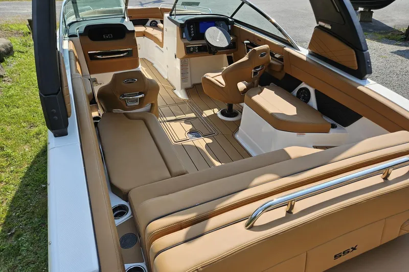 Slide: The Image of 2025 Chaparral 267 SSX boat interior with tan leather seating and modern dashboard. - 6