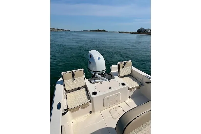 Slide: The Image of 2023 Carolina Skiff 21 LS boat interior with seating and outboard motor on calm water. - 11