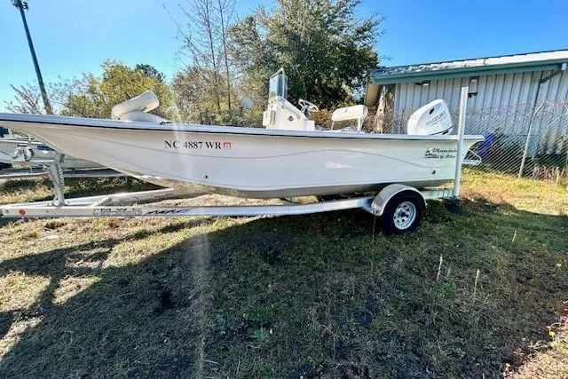 Slide: The Image of 2023 Carolina Skiff 21 LS boat on trailer, parked outdoors near a building. - 15