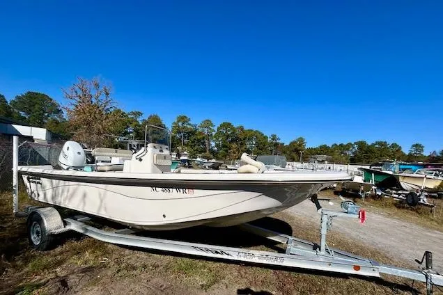 Slide: The Image of 2023 Carolina Skiff 21 LS boat on trailer, parked outdoors under clear blue sky. - 16