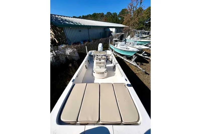 Slide: The Image of 2023 Carolina Skiff 21 LS boat with beige seating, parked outdoors. - 21