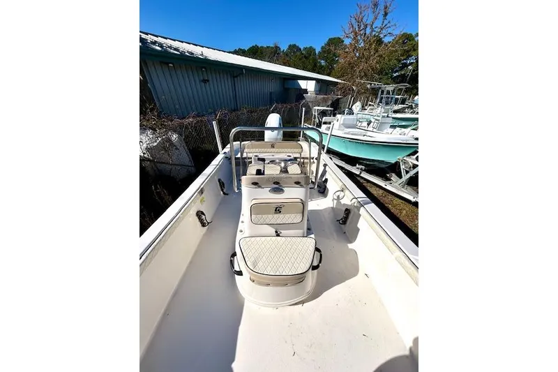 Slide: The Image of 2023 Carolina Skiff 21 LS boat, white interior, parked outdoors near other boats. - 22