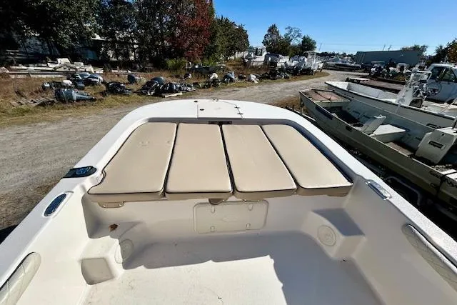 Slide: The Image of 2023 Carolina Skiff 21 LS boat with cushioned seating, docked outdoors. - 3