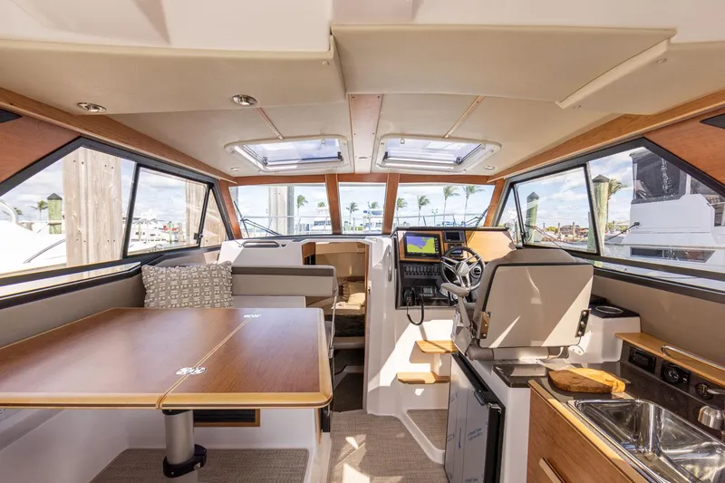 Slide: The Image of Interior of 2025 Cutwater C-288 Coupe LE, featuring helm, seating, and kitchenette. - 17