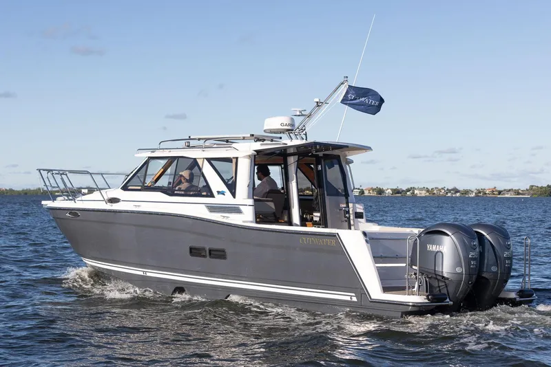 Slide: The Image of 2025 Cutwater C-288 Coupe LE cruising on open water with dual Yamaha engines. - 2