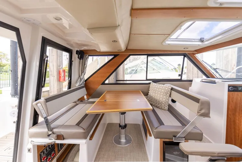 Slide: The Image of Interior of 2025 Cutwater C-288 Coupe LE, featuring a cozy dining area with cushioned seating. - 22