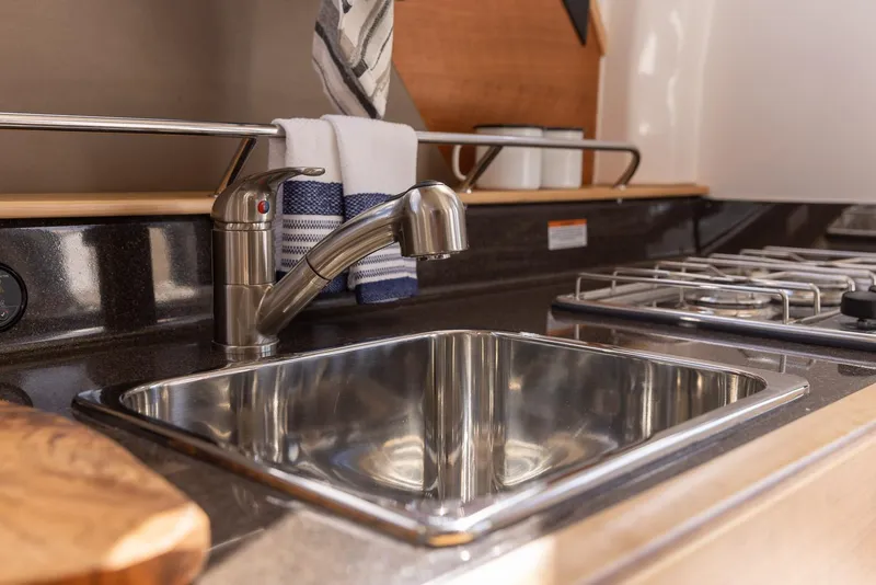 Slide: The Image of Modern kitchen sink and stove in 2025 Cutwater C-288 Coupe LE boat. - 25