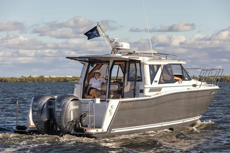 Slide: The Image of 2025 Cutwater C-288 Coupe LE cruising on open water with twin Yamaha engines. - 3