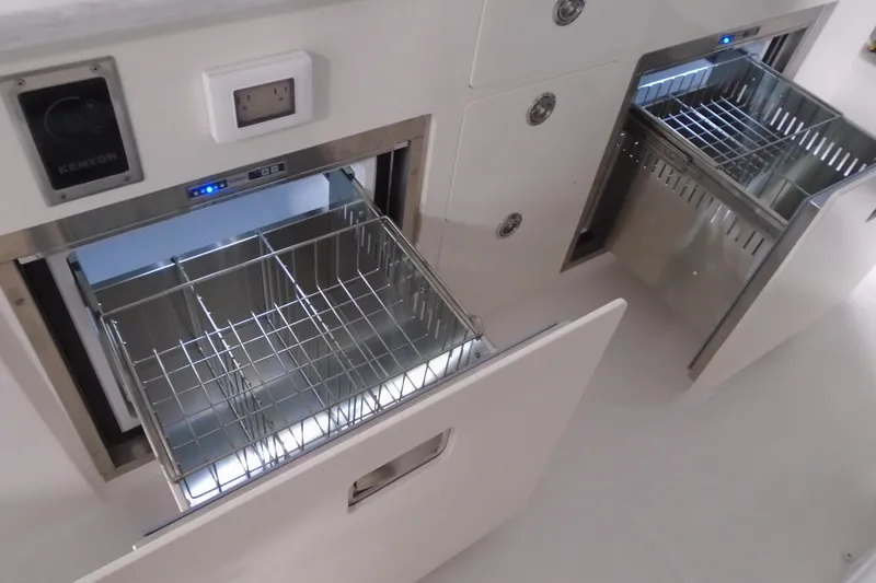 Slide: The Image of 2026 Regal 38 SAV boat kitchen with open stainless steel drawers and appliances. - 24