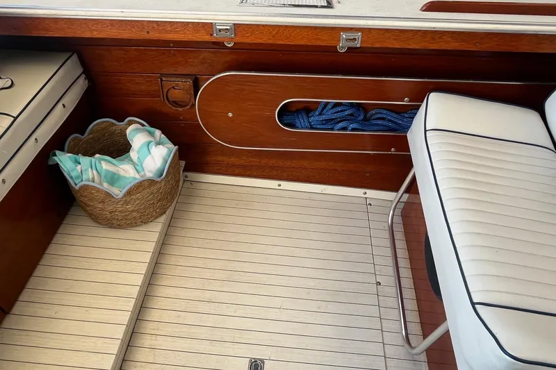 Slide: The Image of 1984 Skiff Craft 26 Runabout interior with wooden paneling and white seating. - 10