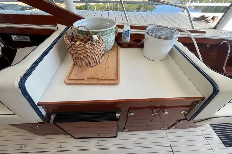 Slide: The Image of 1984 Skiff Craft 26 Runabout interior with wicker basket, cutting board, and bucket on seating area. - 15