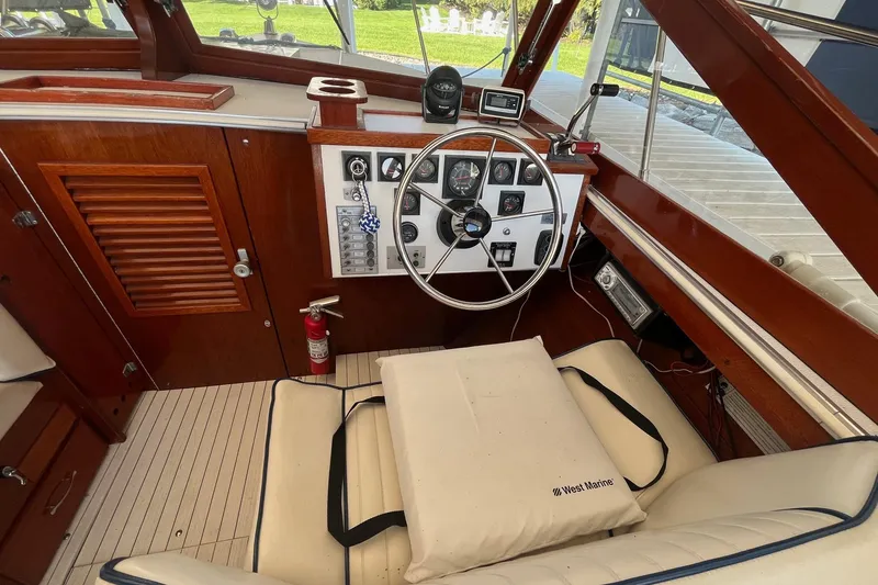 Slide: The Image of 1984 Skiff Craft 26 Runabout cockpit with wooden dashboard, steering wheel, and West Marine cushion. - 18