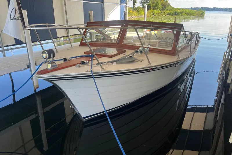 Slide: The Image of 1984 Skiff Craft 26 Runabout boat docked in a covered marina. - 3