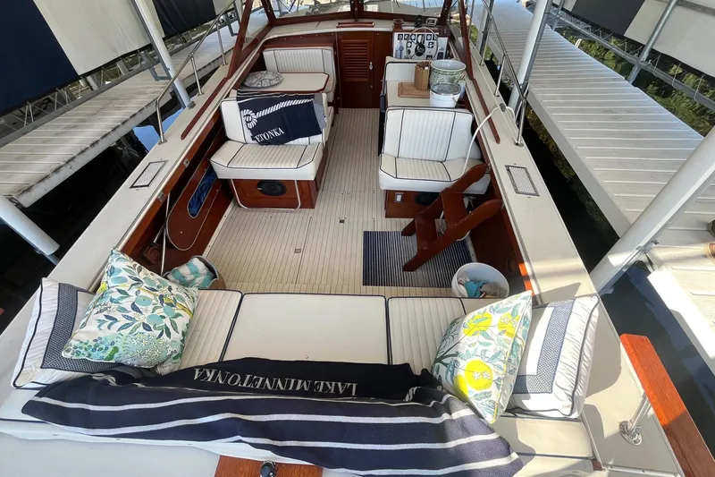 Slide: The Image of 1984 Skiff Craft 26 Runabout interior with cushioned seating and decorative pillows. - 6