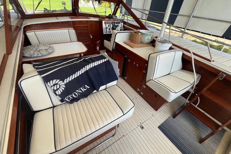 Slide: The Image of 1984 Skiff Craft 26 Runabout interior with white seating, wooden accents, and nautical decor. - 7