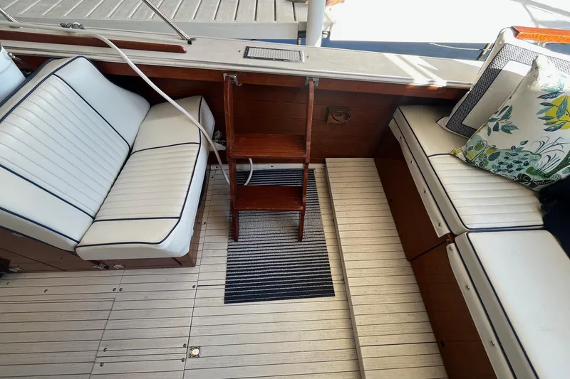 Slide: The Image of 1984 Skiff Craft 26 Runabout interior with white seating and wooden accents. - 8