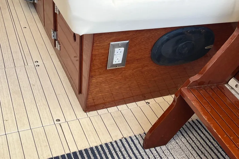 Slide: The Image of 1984 Skiff Craft 26 Runabout interior with wood paneling, electrical outlet, and speaker. - 9