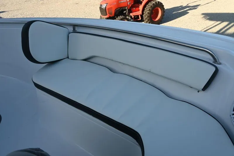 Slide: The Image of 2026 Tidewater 198 CC Adventure boat interior with cushioned seating and visible tractor in background. - 18