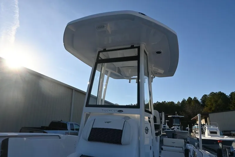 Slide: The Image of 2026 Tidewater 198 CC Adventure boat with T-top, docked under clear blue sky. - 4