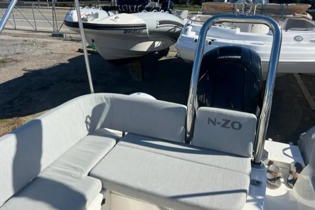 Slide: The Image of 2023 Zodiac N-ZO 680 boat interior with cushioned seating and outboard motor. - 11