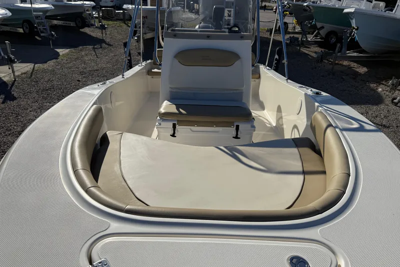 Slide: The Image of 2016 Pioneer 180 Islander boat with beige seating, parked outdoors. - 10