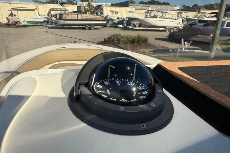 Slide: The Image of Compass on 2016 Pioneer 180 Islander boat dashboard, with other boats in the background. - 18