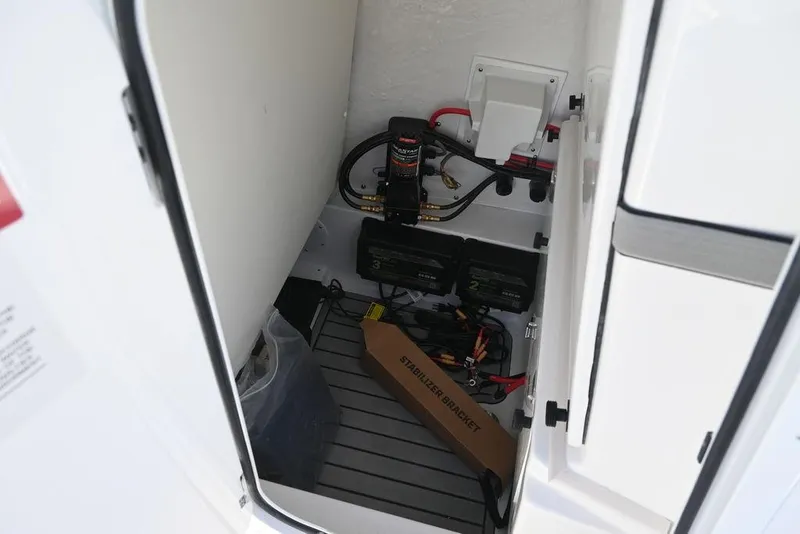 Slide: The Image of 2026 Tidewater 2500 Carolina Bay boat storage compartment with electrical components and stabilizer bracket. - 21