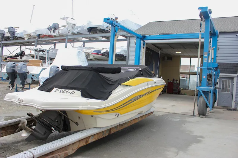 Slide: The Image of Yellow 2007 Azure AZ228 boat in storage facility with blue lift equipment. - 2