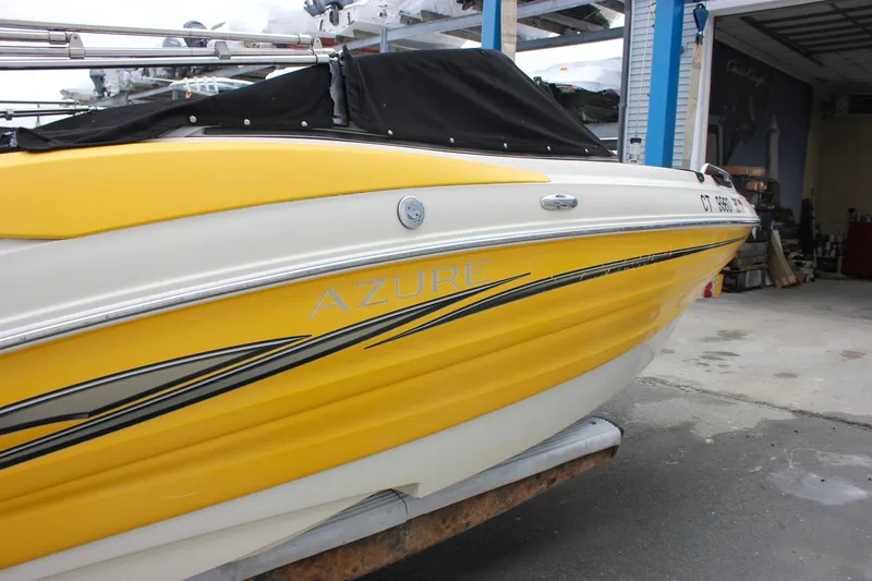 Slide: The Image of Yellow 2007 Azure AZ228 boat with black cover in a garage setting. - 3