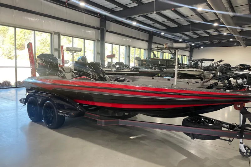 Slide: The Image of 2022 Skeeter FXR20 Apex bass boat in showroom, featuring sleek red and black design. - 10