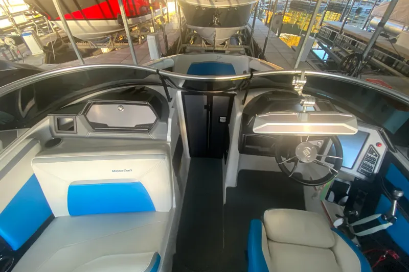 Slide: The Image of 2019 MasterCraft XStar boat interior with blue and white seating, steering wheel, and dashboard. - 21
