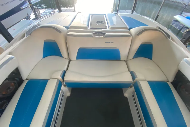 Slide: The Image of 2019 MasterCraft XStar boat interior with white and blue seating arrangement. - 26