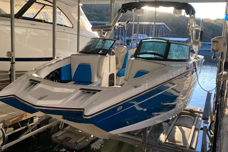 Slide: The Image of 2019 MasterCraft XStar boat with blue and white design docked in marina. - 3
