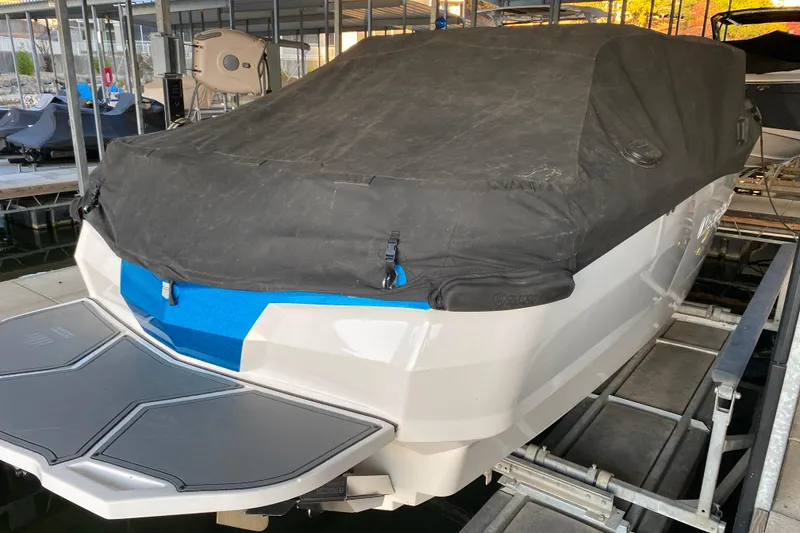 Slide: The Image of 2019 MasterCraft XStar boat covered and docked in a marina. - 33