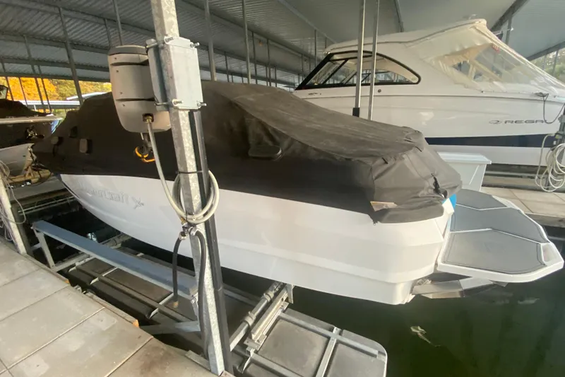 Slide: The Image of 2019 MasterCraft XStar boat covered and docked in a marina. - 34