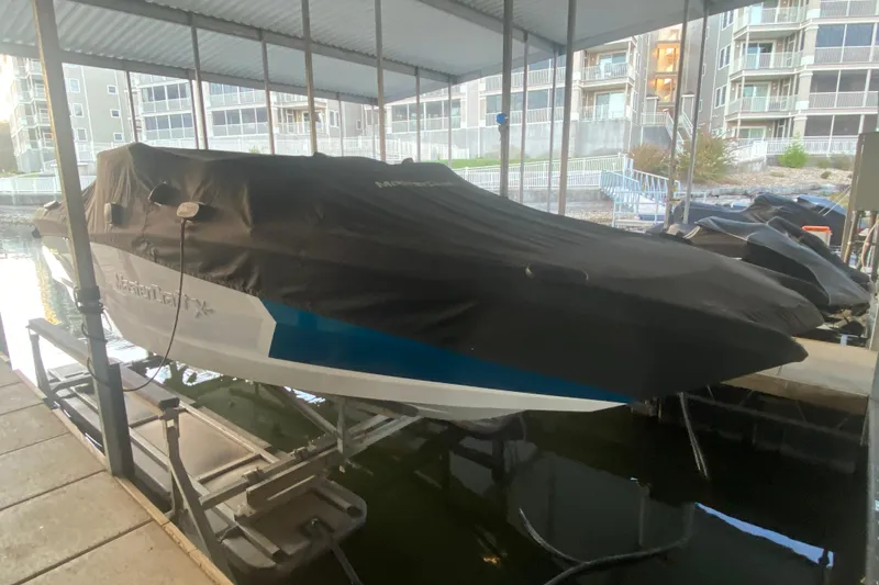 Slide: The Image of 2019 MasterCraft XStar boat covered in a dock, surrounded by modern buildings. - 35