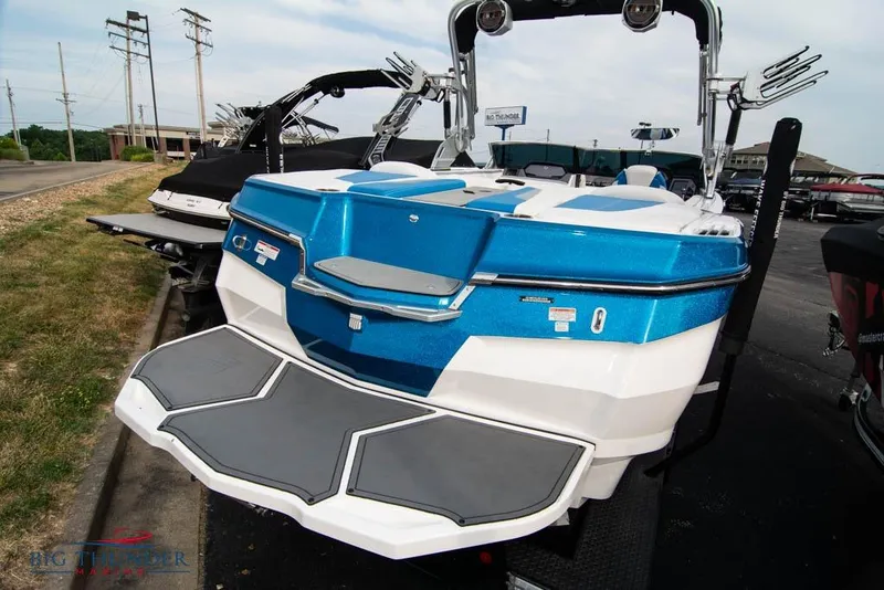 Slide: The Image of 2019 MasterCraft XStar boat with blue and white design, parked outdoors. - 37
