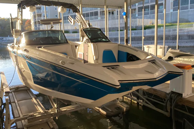 Slide: The Image of 2019 MasterCraft XStar boat docked in a marina, featuring sleek blue and white design. - 5