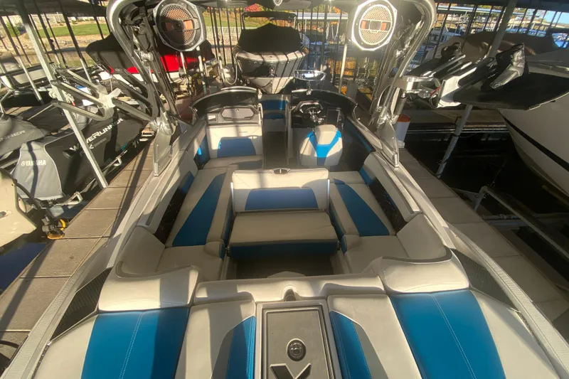 Slide: The Image of 2019 MasterCraft XStar boat interior with blue and white seating, docked in a marina. - 9
