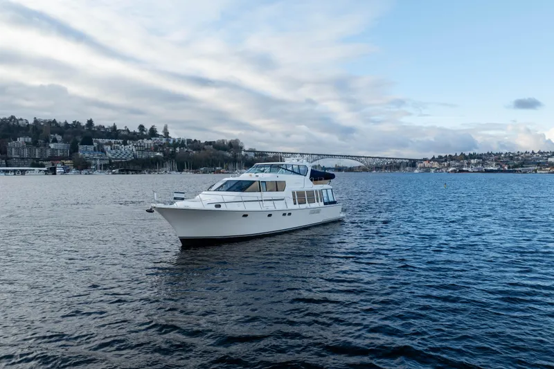 Slide: The Image of 2005 Pacific Mariner 65 Diamond yacht on a scenic waterway with bridge and cityscape. - 15