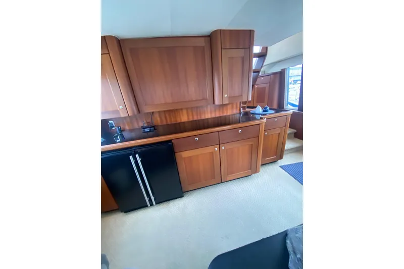 Slide: The Image of 2005 Pacific Mariner 65 Diamond yacht cruising near a city skyline under cloudy skies. - 7