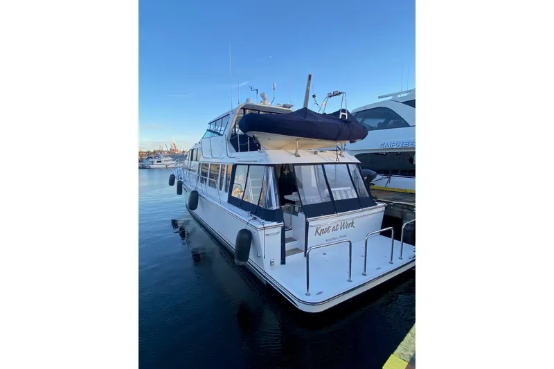 Slide: The Image of 2005 Pacific Mariner 65 Diamond yacht on calm waters with cityscape background. - 9